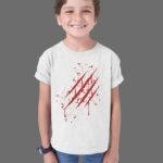 Un enfant souriant porte un t-shirt blanc avec un motif amusant au centre, représentant une sorcière joyeuse accompagnée de l'inscription "Un bonbon ou un sort". Ce design ludique crée un effet visuel captivant, parfait pour Halloween. Le t-shirt à manches courtes présente une coupe confortable et ample, idéale pour un style décontracté et actif. Ainsi, votre enfant peut s'amuser tout en étant à la mode pour la fête !